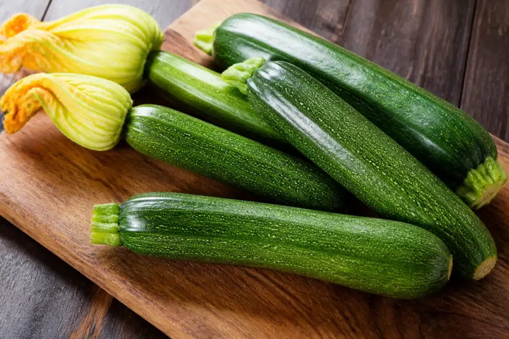 Jonge courgettes met glanzende groene schil op snijplank