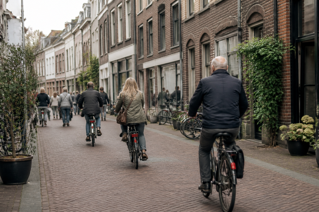 Drukke winkelstraat met fietsers en oude bakstenen gevels